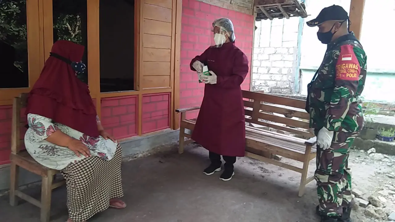 Babinsa dari Kodim 0721/Blora dengan didampingi tenaga medis mendistribusikan obat secara gratis untuk pasien Covid-19 dengan gejala ringan atau OTG yang menjalani isoman. (Liputan6.com/Ahmad Adirin)