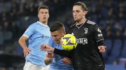 Gelandang Lazio, Mattia Zaccagni (tengah) berebut bola dengan gelandang Juventus, Adrien Rabiot pada laga pekan ke-29 Liga Italia 2022/2023 di Olimpico Stadium, Roma, Minggu (9/4/2023) dini hari WIB. (AP Photo/Alessandra Tarantino)