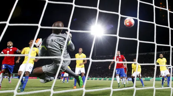 Penjaga gawang Brazil Jefferson salah mengantisipasi bola yang ditendang Eduardo Vargas pada laga kualifikasi Piala Dunia 2018 di Santiago, Chile, Kamis (08/10/2015). Chile menang 2-0. (REUTERS/Ivan Alvarado)