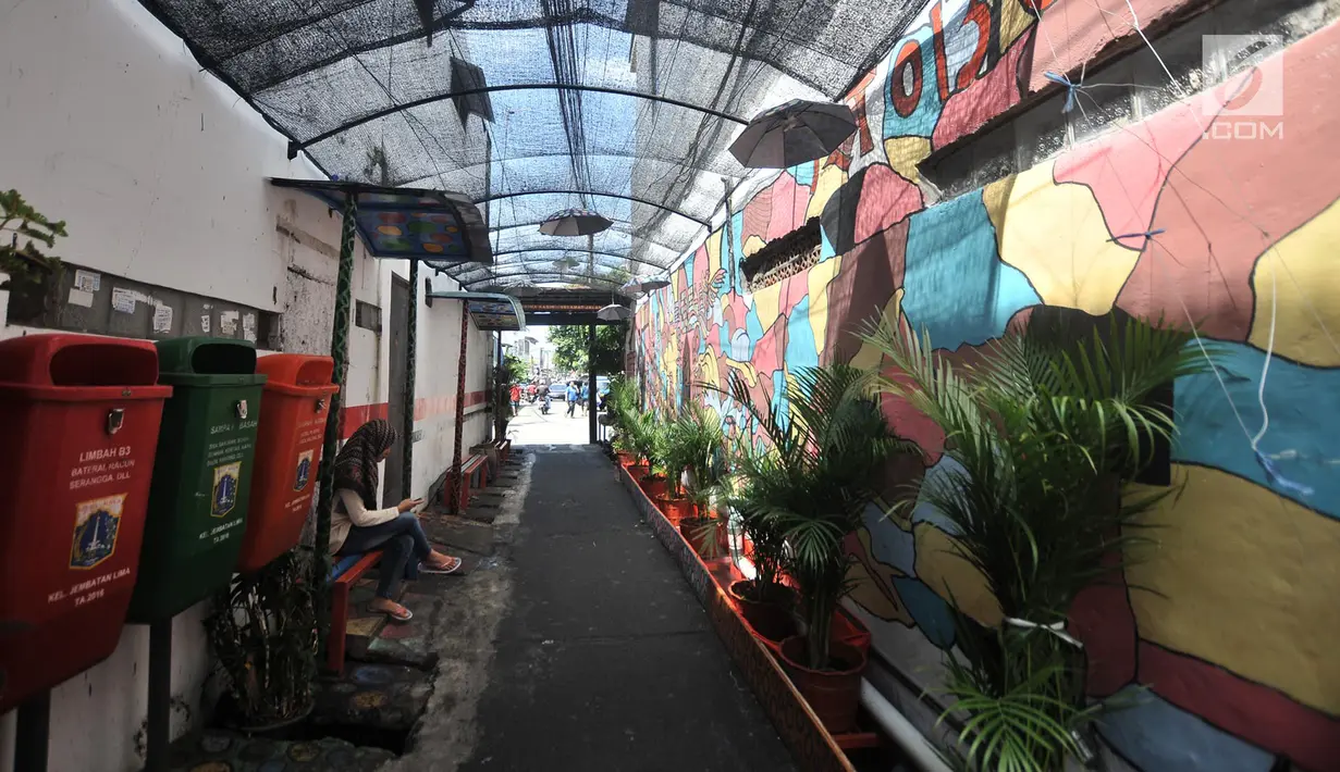 Aktivitas warga di gang di RT 13 RW 06, Jembatan Lima, Jakarta, Kamis (10/1). Warna-warni mural di pemukiman padat penduduk itu merupakan ide Aryanto selaku Ketua RT 13. (Merdeka.com/Iqbal Nugroho)