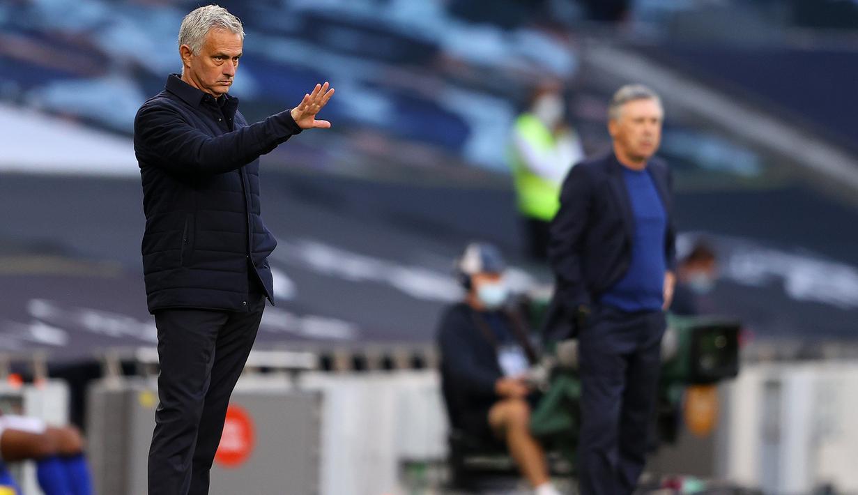 Pelatih Tottenham Hotspur, Jose Mourinho, dan pelatih Everton, Carlo Ancelotti, pada laga Premier League, Senin (6/7/2020). Mourinho rela langgar aturan jarak sosial demi memeluk Carlo Ancelotti. (AFP/Richard Heathcote)