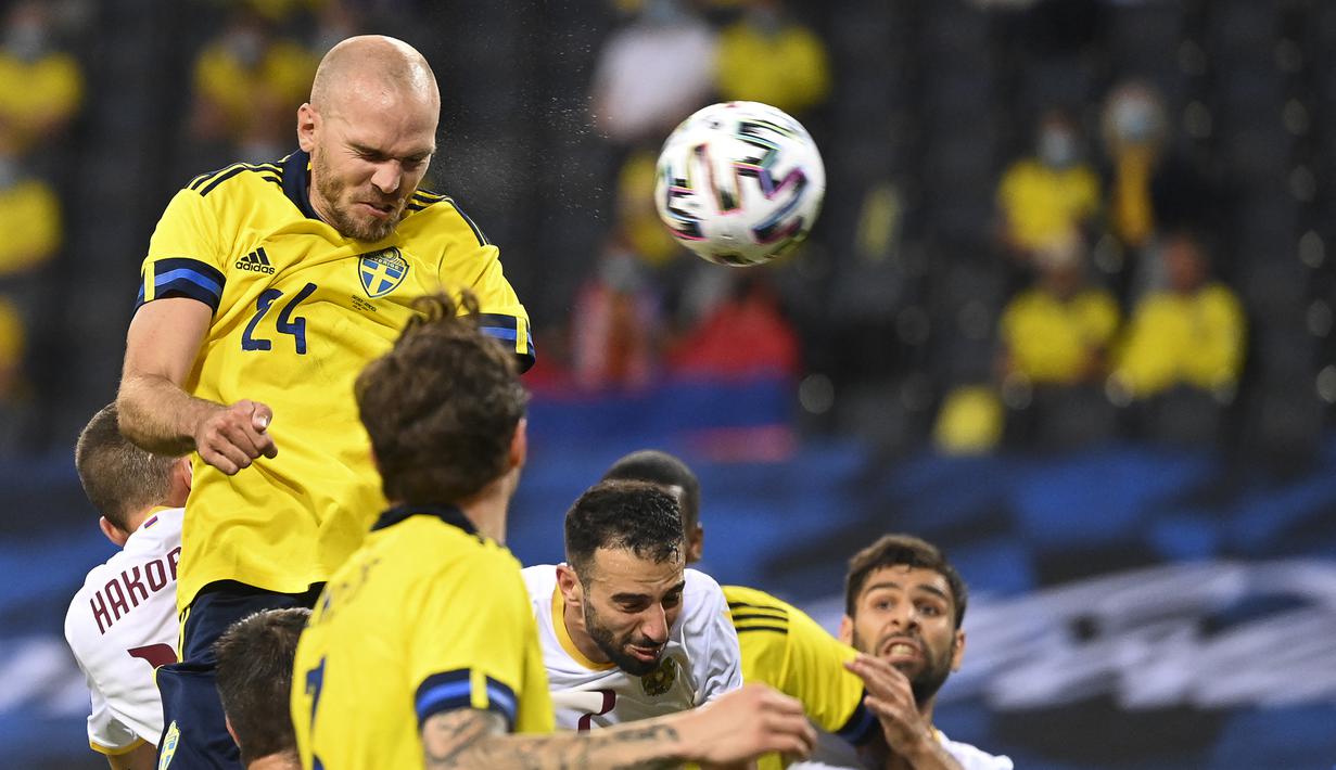 Bek Swedia, Marcus Danielson (kiri) melepaskan sundulan yang berbuah gol kedua ke gawang Armenia dalam laga uji coba menjelang berlangsungnya Euro 2020 di Solna, Sabtu (5/6/2021). Swedia menang 3-1 atas Armenia. (AFP/Jonathan Nackstrand)