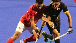 Atlet hoki Indonesia berebut bola saat bertanding melawan Jepang dalam babak penyisihan hoki putra Asian Games di Lapangan Hoki Gelora Bung Karno, Jakarta, Rabu (22/8). Indonesia kalah dengan skor 1-3. (Liputan6.com/Fery Pradolo)