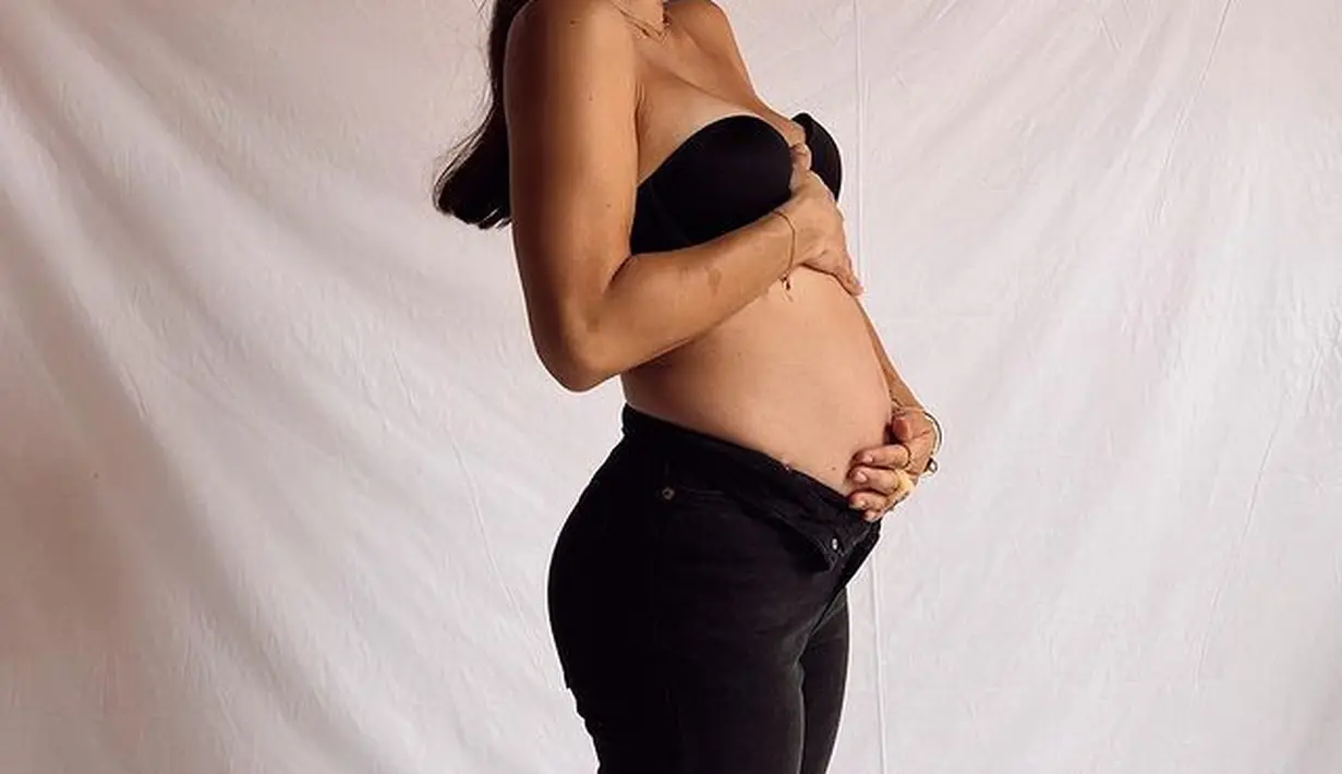 Dalam potret terbaru, Jennifer menunjukkan baby bumpnya. Dengan mengenakan strapless bra dan celana panjang hitam. (instagram/jenniferbachdim)
