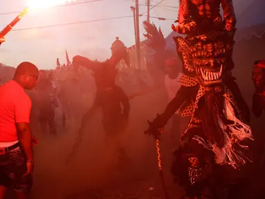 Sejumlah warga merayakan festival Congos and Devils di luar benteng San Jeronimo di Portobelo, Panama (18/3). Festival ini adalah perpaduan budaya Katolik dan keyakinan Afrika yang digelar sejak tahun 1999. (AP Photo/Arnulfo Franco)