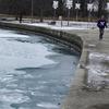 Salju dan es menutupi Danau Michigan saat seorang pria berlari di Pantai Montrose di Chicago (17/1/2022). Badai salju Chicago diperkirakan akan membawa hingga 5 inci di sepanjang Danau Michigan. (AP Photo/Nam Y. Huh)