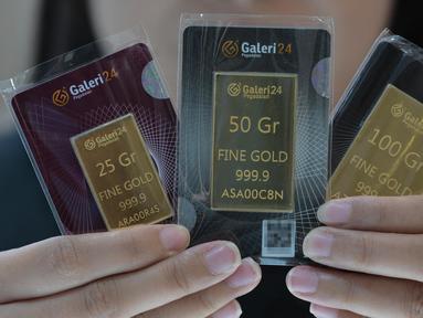 Seorang karyawan menunjukkan emas batangan 25, 50, dan 100 gram produksi Galeri 24, anak perusahaan dari PT Pegadaian (Persero), di Jakarta pada 14 April 2025. (BAY ISMOYO/AFP)