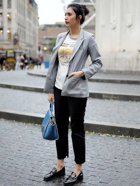 Kalau yang satu ini, Tyas bergaya semi formal dengan blazer dan kaos serta pencil skirtnya. Bun hair andalannya pun tak ketinggalan menemaninya saat liburan. (Instagram/tyasmirasih)