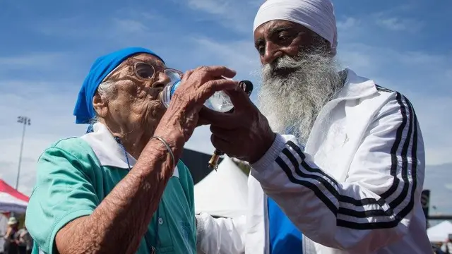 Gurdev Singh memberi minum ibunya, Man Kaur usai menyelesaikan lomba lari 100 meter