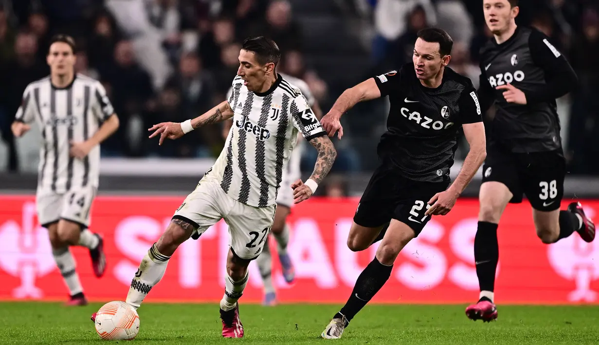 Pemain depan Juventus Angel Di Maria berebut bola dengan gelandang Freiburg, Nicolas Hoefler dalam laga leg pertama babak 16 besar Liga Europa 2022-2023 di Allianz Stadium, Jumat (10/3/2023) dini hari WIB. Pasukan Allegri menyelesaikan laga dengan keunggulan 19 usaha ke gawang berbanding hanya satu dari Freiburg. (Photo by Marco BERTORELLO / AFP)