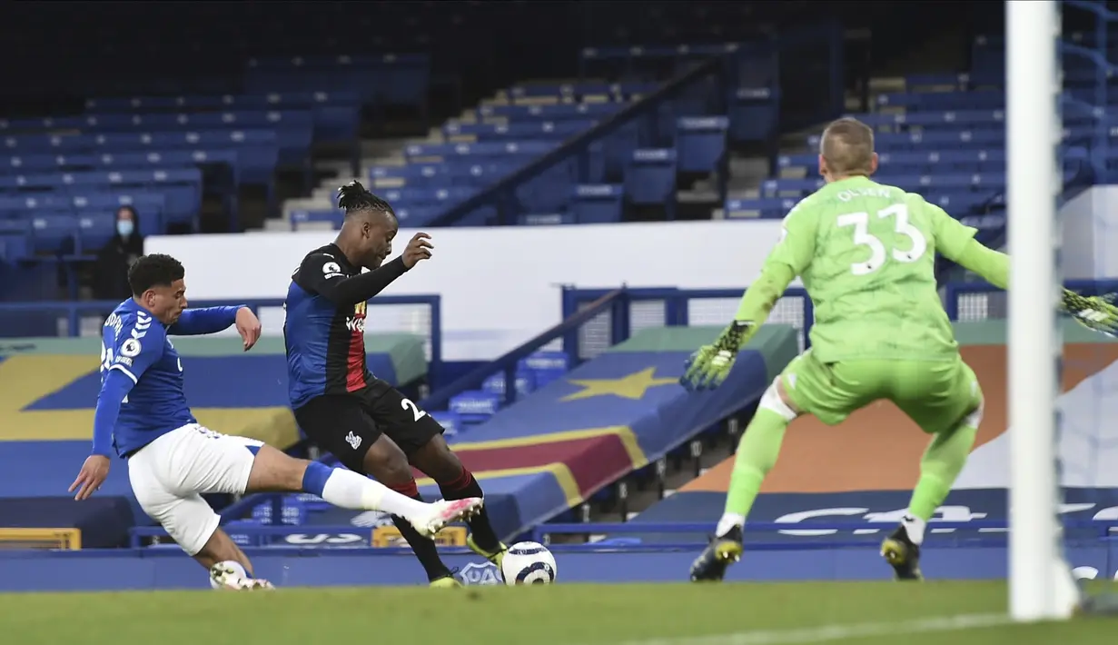 Striker Crystal Palace, Michy Batshuayi (tengah) melepaskan tendangan yang berbuah gol penyeimbang 1-1 ke gawang Everton dalam laga lanjutan Liga Inggris 2020/2021 pekan ke-30 di Goodison Park, Liverpool, Senin (5/4/2021). Crystal Palace bermain imbang 1-1 dengan Everton. (AP/Peter Powell/Pool)