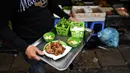 Pedagang membawa kuliner cha ruoi di sebuah kios di Hanoi, Vietnam, Jumat (14/12). Cha ruoi menjadi kudapan favorit saat musim dingin di Vietnam. (Manan Vatsyayana/AFP)