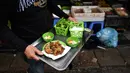 Pedagang membawa kuliner cha ruoi di sebuah kios di Hanoi, Vietnam, Jumat (14/12). Cha ruoi menjadi kudapan favorit saat musim dingin di Vietnam. (Manan Vatsyayana/AFP)