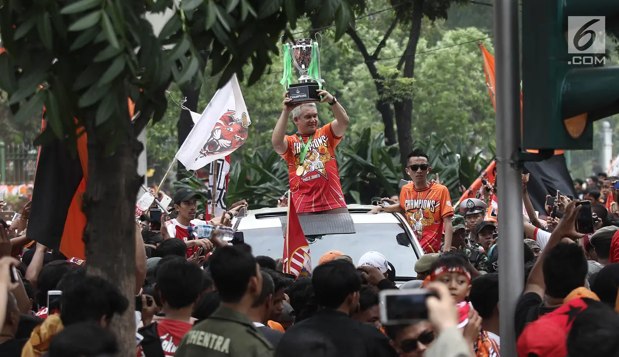Ketua Umum The Jakmania, Tauhid Indrasjarief alias Bung Ferry mengangkat piala Liga I di depan Balai Kota, Jakarta, Sabtu (15/12). (Liputan6.com/Herman Zakharia)