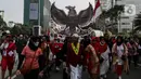 Peserta mengarak poster bergambar Garuda Pancasila ketika mengikuti Kirab Merah Putih di Jakarta, Minggu (28/8/2022). Sebanyak 50.000 orang membentangkan bendera merah putih sepanjang 1.700 meter dari kawasan Monas hingga Bundaran Hotel Indonesia dalam rangka memperingati HUT ke-77 Kemerdekaan Republik Indonesia bertemakan 'Pulih Lebih Cepat, Bangkit Lebih Kuat. (Liputan6.com/Johan Tallo)