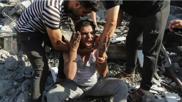 Warga Palestina menenangkan seseorang yang kehilangan rumah akibat serangan Israel. (AP)