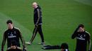 Pelatih Real Madrid, Zinedine Zidane (tengah) melihat para pemainnya berlatih di fasilitas olahraga Real Madrid City di Madrid (17/12/2019). Real Madrid akan bertanding melawan Barcelona dalam laga El Clasico di Nou Camp. (AFP/Javier Soriano)