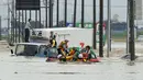 Petugas pemadam kebakaran mengevakuasi warga yang terjebak luapan banjir dari Sungai Kinugawa di Joso, prefektur Ibaraki, Jepang, Kamis (10/9). Satu orang hilang dan lebih dari 90 ribu warga diperintahkan untuk mengungsi. (REUTERS/Kyodo)