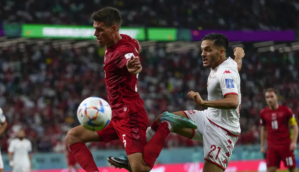 <p>Pemain Denmark, Joakim Maehle berebut bola dengan pemain Tunisia, Wajdi Kechrida selama pertandingan grup D Piala Dunia 2022 Qatar di Education City Stadium di Al Rayyan, Qatar, Selasa (22/11/2022). Denmark bermain imbang dengan Tunisia 0-0. (AP Photo/Manu Fernandez)</p>