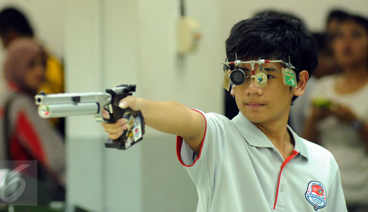 Petembak Junior Indonesia, I Kadek Rico V (kiri) saat laga melawan Abdul Hadi Abd Malek di Final 10m Air Pistol Men Junior Kejuaraan Menembak ASEAN di Jakarta, Rabu (25/11/2015). Kadek meraih emas dengan 196.7 poin. (Liputan6.com/Helmi Fithriansyah) 