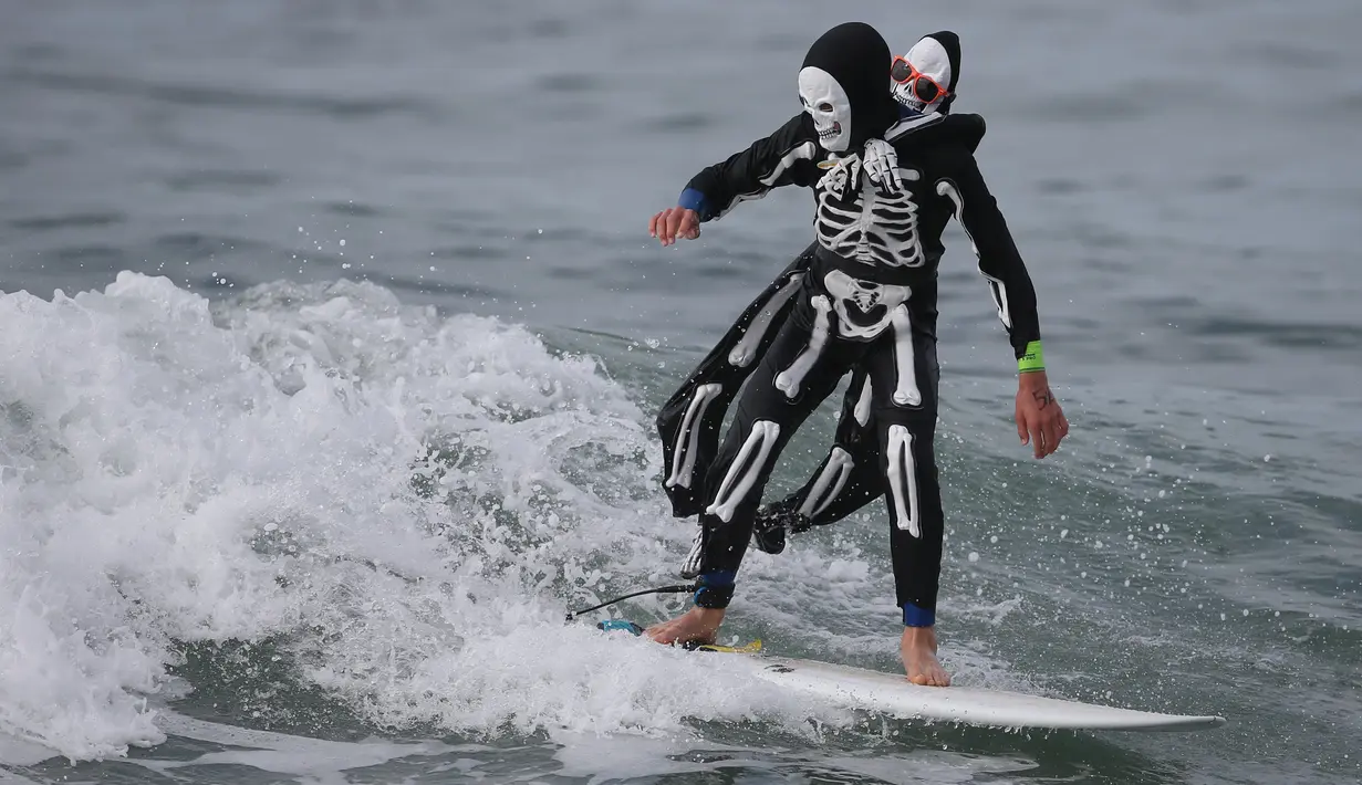 Peserta menggunakan kostum tengkorak saat mengikuti kontes surfing Haunted Heats Halloween di Santa Monica, California, (29/10). Acara ini untuk merayakan hari Halloween yang jatuh pada tanggal 31 Oktober. (REUTERS/Lucy Nicholson)