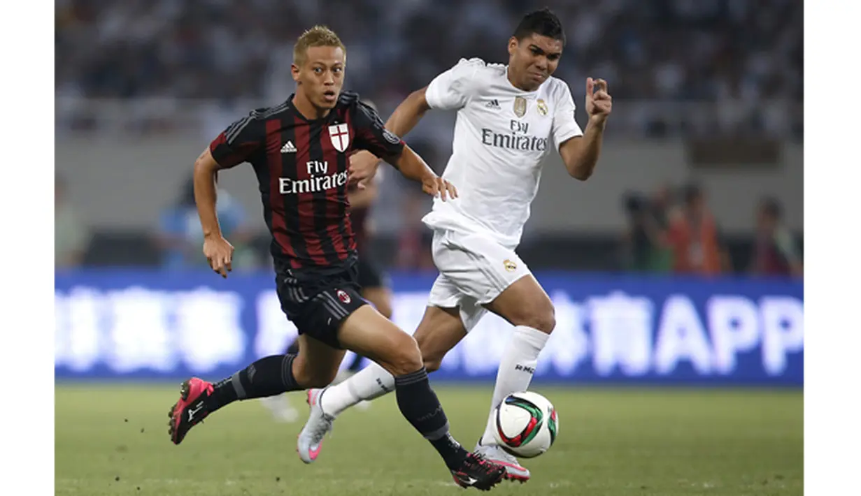 Pemain AC Milan Keisuke Honda menggiring bola melewati hadangan pemain Real Madrid, Casemiro pada laga International Champions Cup 2015 di Shanghai, China, Kamis (30/7). (Reuters Aly Song)
