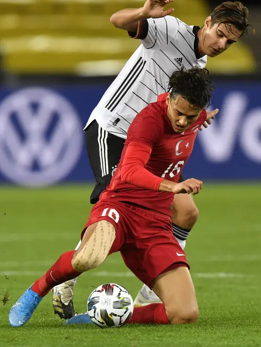 Gelandang Jerman, Kai Havertz membawa bola dari kejaran pemain Turki, Ozan Tufan pada pertandingan persahabatan di Stadion RheinEnergie, Cologne, Kamis  (8/10/2020). Jerman bermain imbang 3-3 atas Turki. (AP Photo/Martin Meissner)