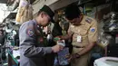 Petugas gabungan melaksanakan razia peredaran obat tramadol di kawasan KS Tubun, Tanah Abang, Jakarta Pusat, Selasa (13/10/2026). Tramadol merupakan obat pereda nyeri yang penggunaannya harus berdasarkan resep dan pengawasan tenaga medis untuk menghindari risiko kesehatan akibat penyalahgunaan. (KLY/Budy Santoso)