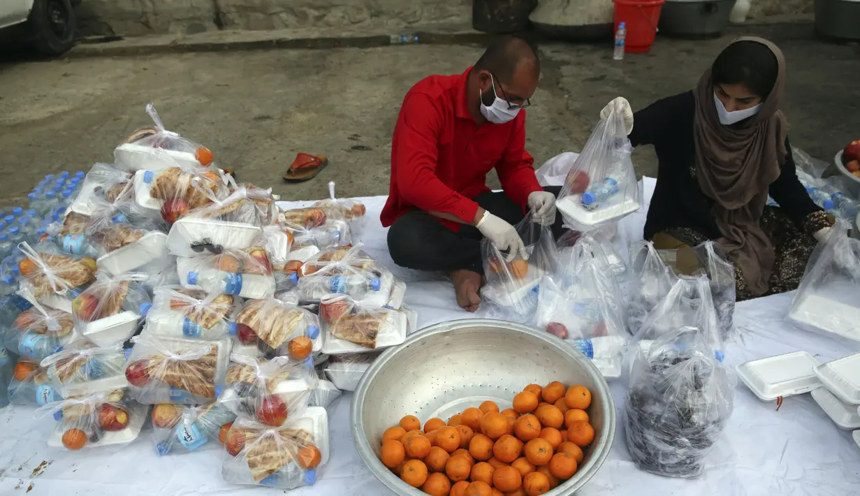 Sukarelawan menyiapkan makanan berbuka puasa gratis untuk orang-orang yang membutuhkan selama bulan puasa suci Ramadan di Kabul, Afghanistan, Kamis (7/5/2020). Muslim di seluruh dunia melewati Ramadan tahun ini di tengah pandemi virus corona COVID-19 dan PHK. (AP Photo/Rahmat Gul)