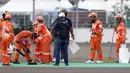 Marshal membersihkan lintasan jelang kualifikasi MotoGP di Pertamina Mandalika International Street Sirkuit, Lombok, Sabtu (19/3/2022). Startline Marshals memastikan bahwa semua pembalap berada dengan benar di grid start. (Liputan6.com/Helmi Fithriansyah)