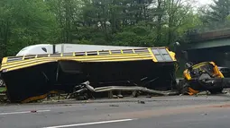 Kondisi bus sekolah yang terbalik setelah bertabrakan dengan truk sampah di Interstate 80, Mount Olive, New Jersey, Kamis (17/5). Bus membawa siswa kelas V East Brook Middle School di Paramus, menuju Waterloo untuk karyawisata. (Chrissy Oleszek via AP)