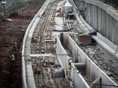 Pekerja berada di proyek Light Rail Transit (LRT) di sisi jalan Tol Jagorawi, Cibubur, Jakarta, Jumat (2/6). Pembangunan LRT Jabodebek koridor Cawang-Cibubur sudah mencapai 25 persen dan ditarget rampung pada 2019. (Liputan6.com/Faizal Fanani)