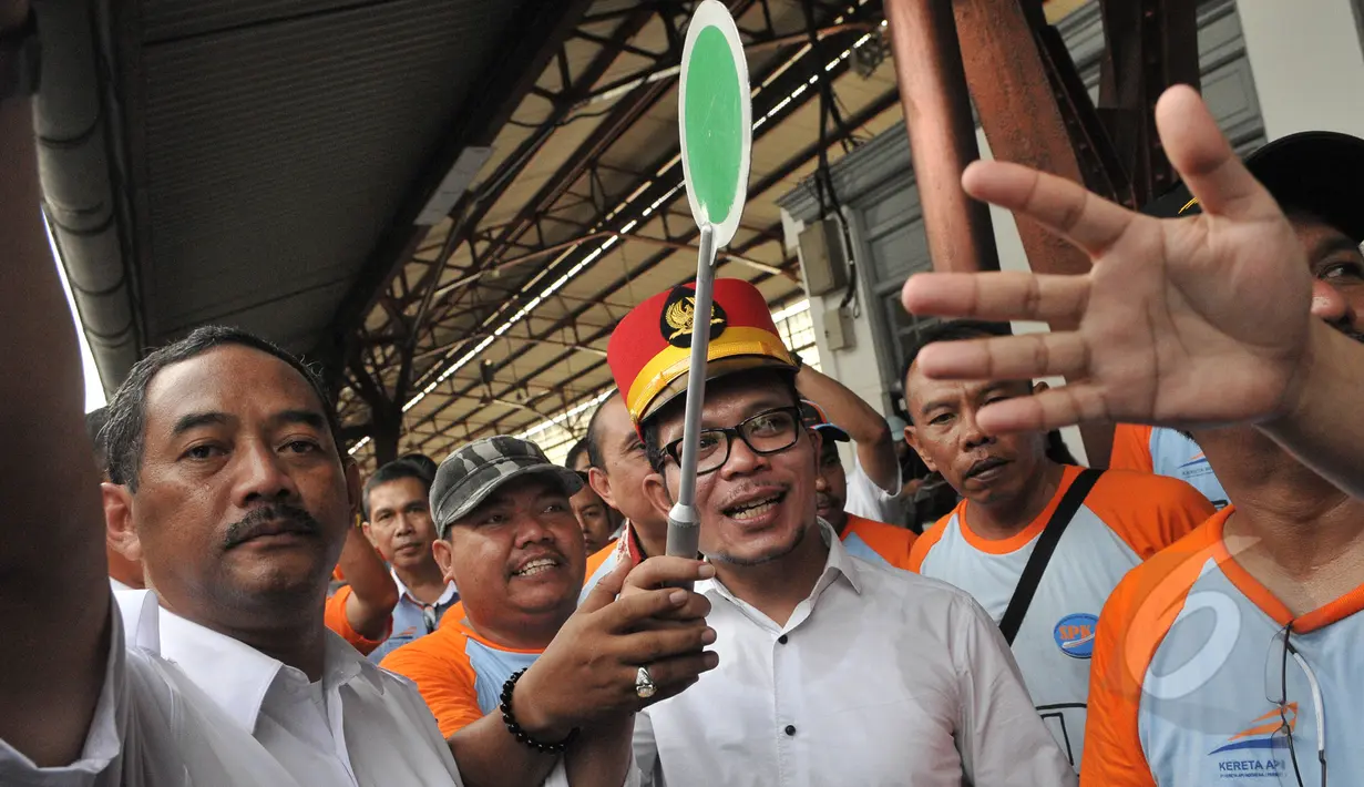 Menaker Hanif Dhakiri (tengah) menyilakan kereta api untuk berangkat di Stasiun Pasar Senen, Jakarta, Jumat (1/5). Menaker memperingati Hari Buruh se-Dunia (May Day) dengan mengangkat tema "Bersih-bersih BUMN". (Liputan6.com/Herman Zakharia)