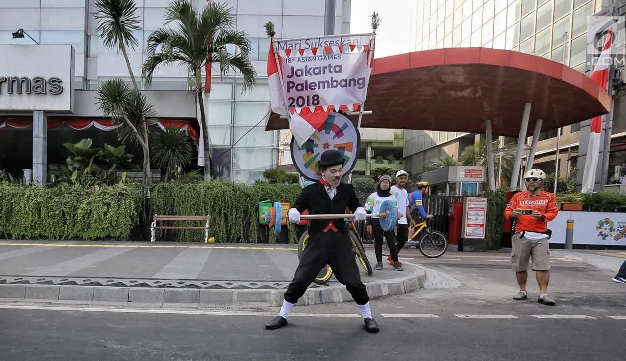 Seniman pantomim beraksi memainkan seni pantomim saat prosesi Torch Relay Asian Games 2018 di Jakarta, Sabtu (18/8). Hari ini merupakan puncak kirab obor Asian Games 2018 dimana api abadi akan berlabuh di Gelora Bung Karno. (Liputan6.com/Faizal Fanani)
