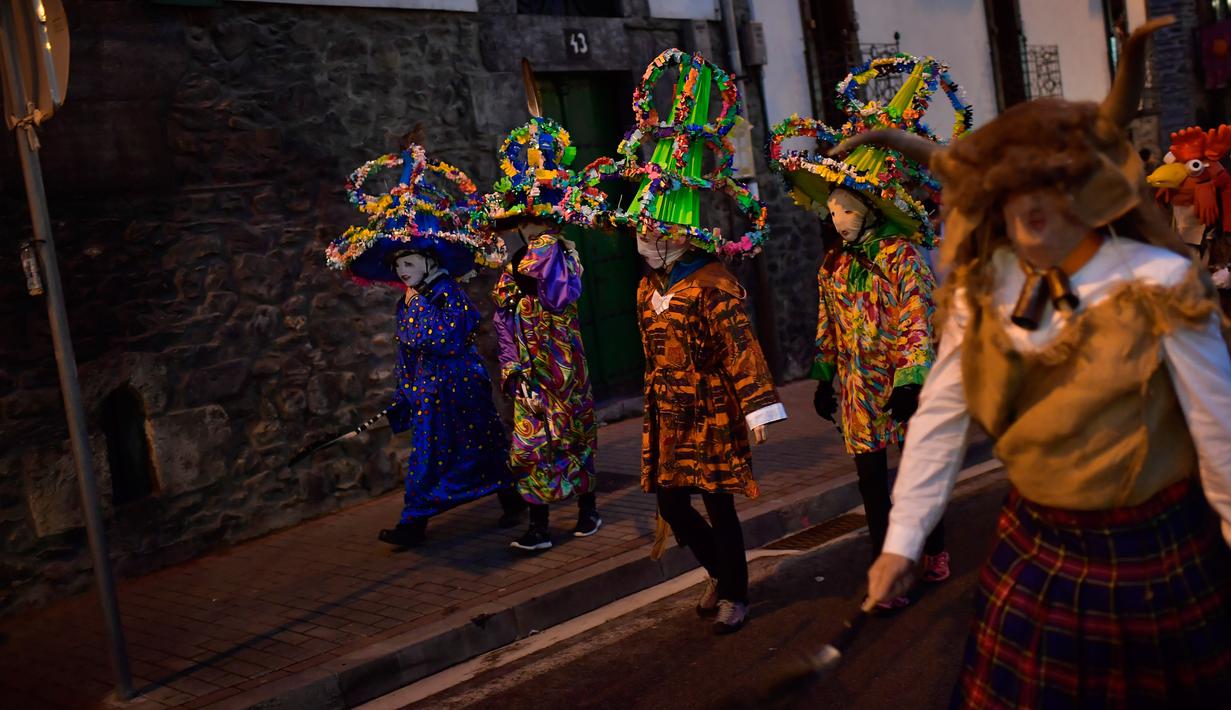 Peserta mengenakan kostum, topeng dan topi yang dikenal sebagai '' Ttutturo '' turun ke jalan saat mengikuti karnaval di desa Pyrenees Leitza, Spanyol (30/1). (AP Photo / Alvaro Barrientos)