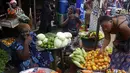 Para perempuan menjual sayuran di pasar Kaporo di Conakry, Guinea Senin (13/9/2021). Pasukan elit militer Guinea melakukan kudeta dan menangkap Presiden Alpha Conde pada Minggu, 5 September lalu. (AP Photo/ Sunday Alamba)