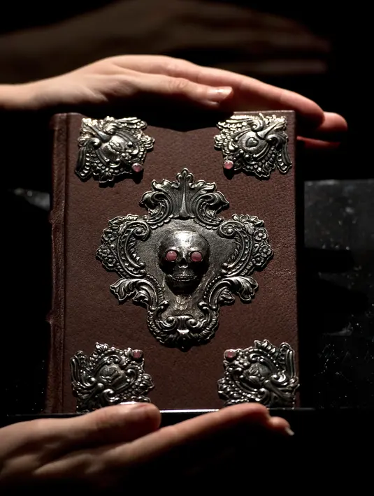 Buku langka yang ditulis tangan dan digambar oleh penulis 'Harry Potter' J.K. Rowling berjudul 'The Tales of Beedle the Bard' diperlihatkan di rumah lelang Sotheby, London, 9 Desember 2016. Buku itu terjual seharga Rp6,2 miliar. (Justin TALLIS/AFP)