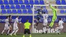 Aksi dari kiper Real Madrid, Thibaut Courtois menepis bola serangan dari pemain Huesca. (Foto: AP/Alvaro Barrientos)