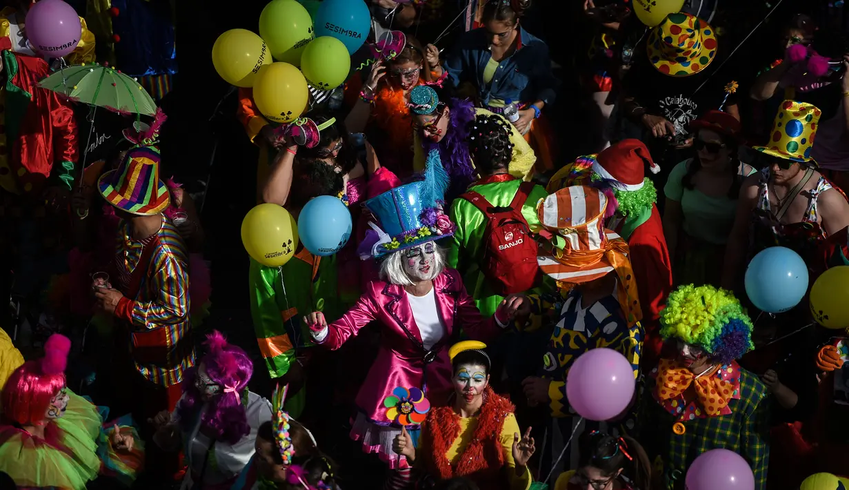 Orang-orang yang mengenakan pakaian badut ikut serta dalam parade badut tahunan di Sesimbra, Portugal pada Senin (4/3/2019). Perayaan ini dilakukan setiap tahun dan jatuh pada hari Senin. (PATRICIA DE MELO MOREIRA / AFP)