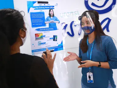 Frontliner kenakan masker melayani nasabah di kantor Asuransi Astra Tendean, di Jakarta, Selasa (1/9/2020). Asuransi Astra ajak warganet turut serta dalam kampanye sosial "Teman Tuli Asuransi Astra" dengan mengunggah foto menggunakan pose bahasa isyarat "cinta" ke Instagram. (Liputan6.com/HO/Eko)