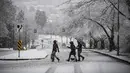 Warga berjalan saat hujan salju yang cukup lebat di Burnaby, British Columbia, Kanada (21/12/2020). Pemerintah setempat mengeluarkan peringatan hujan salju pada hari pertama musim dingin. (Darryl Dyck/The Canadian Press via AP)