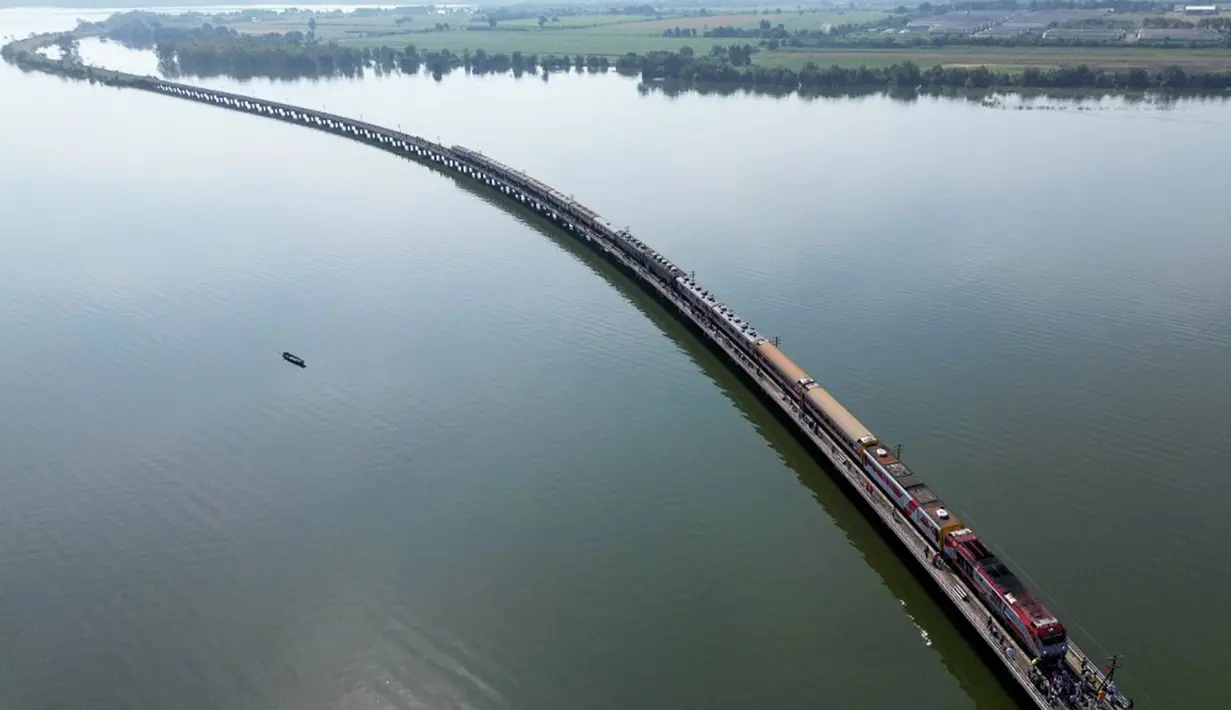 Kereta layang dengan rel di ketinggian sudah cukup banyak. Kereta yang satu ini juga kereta layang, tapi di atas air. (MANAN VATSYAYANA/AFP)