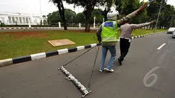 Relawan Saber saat membersihkan paku di jalan di depan Istana Merdeka, Jakarta, Jumat (6/3/2015). Paku yang ditebar oleh orang tidak bertangung jawab seringkali mengganggu para pengguna jalan. (Liputan6.com/Faizal Fanani)