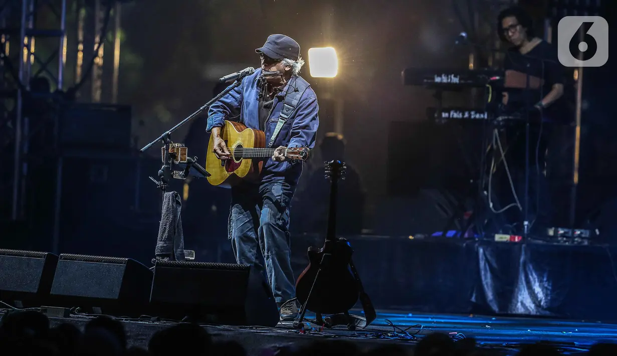 Musisi Iwan Fals tampil pada hari kedua Synchronize Fest 2019 di Gambir Expo, Kemayoran, Jakarta, Sabtu (5/10/2019). Iwan Fals tampil dengan menggendong gitar dan memainkan harmonika. (Liputan6.com/Faizal Fanani)