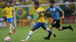 Pemain Brasil Alex Sandro (kiri) berebut bola dengan pemain Uruguay Nahitan Nandez pada pertandingan kualifikasi Piala Dunia 2022 di Arena da Amazonia, Manaus, Brasil, Kamis (14/10/2021). Brasil menang 4-1. (AP Photo/Andre Penner)