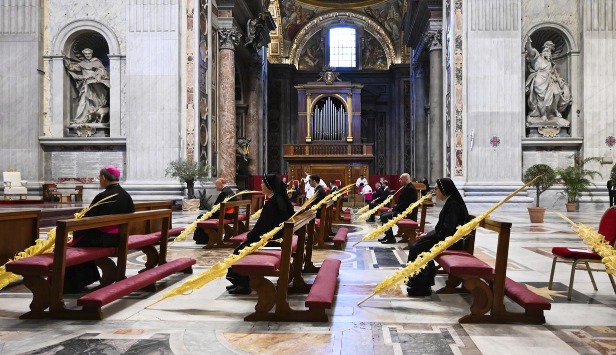 Sejumlah petugas mengikuti Misa Minggu Palma di St. Peter's Basilica, Vatikan, Minggu (5/4/2020). Para petugas tetap menjaga jarak untuk menghindari penyebaran virus corona COVID-19. (AP Photo/pool/Alberto Pizzoli)