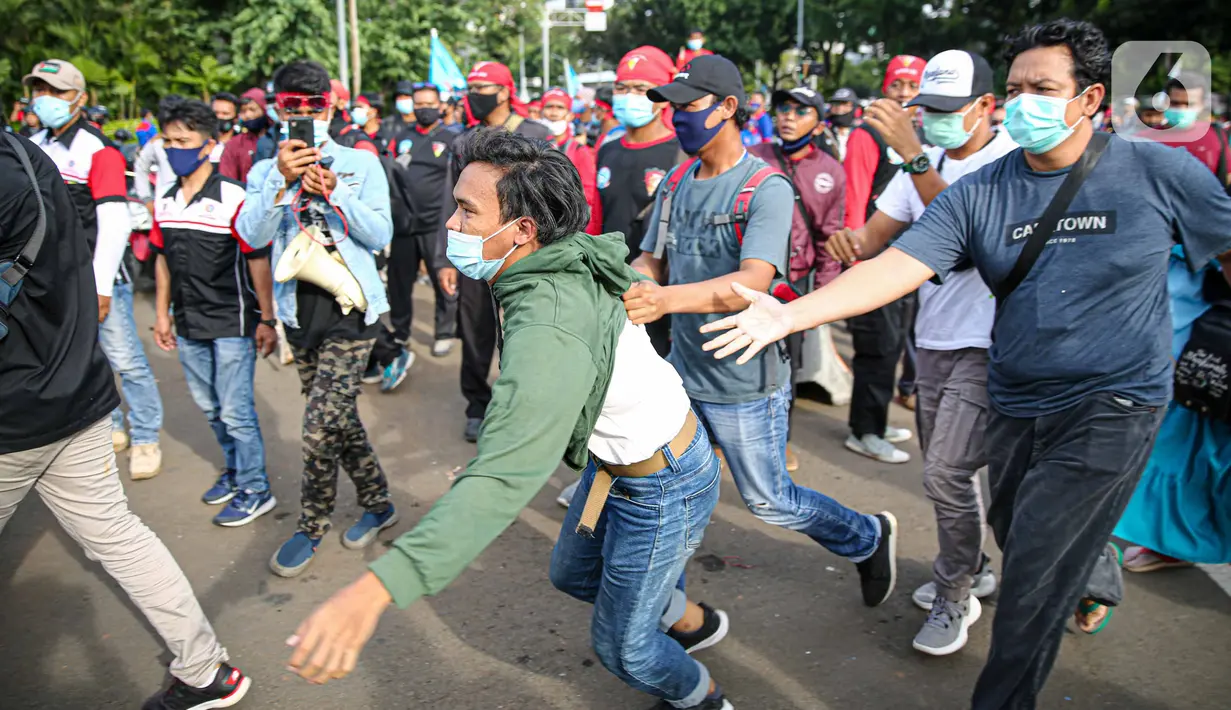 Petugas kepolisian mengamankan massa yang diduga hendak berbuat kericuhan saat aksi unjuk rasa di kawasan Patung Kuda, Jakarta, Kamis (22/10/2020). Penangkapan dilakuka untuk mencegah hal hal yang tak di inginkan saat unjuk rasa. (Liputan6.com/Faizal Fanani)