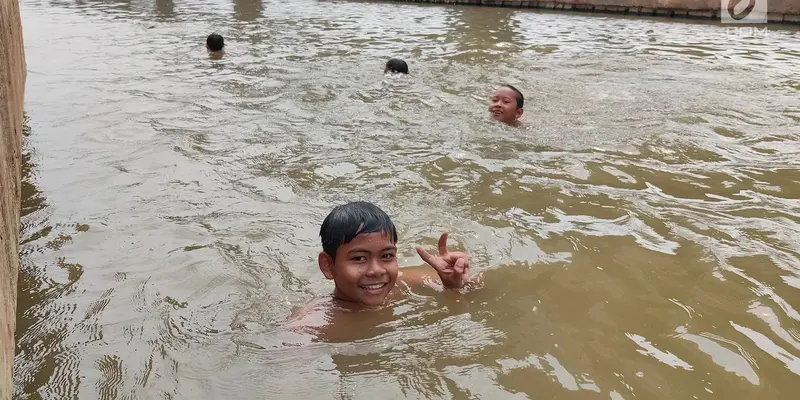 Suhu Ibu Kota Panas, Anak-Anak Ini Berenang di Kalimalang