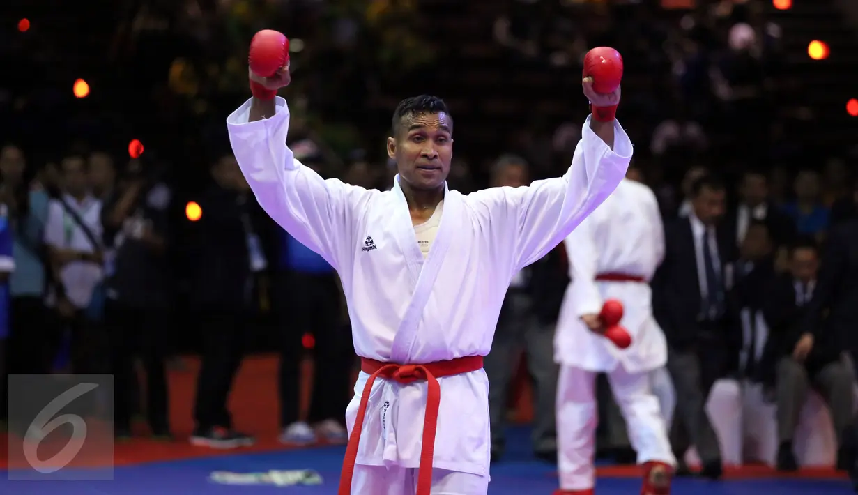 Karateka Jawa Timur, Umar Syarief mengangkat tangan usai menumbangkan Caesar George (Jakarta) di kelas Kumite Individu Putra +84 kg senior PON XIX di Sabuga, Bandung, Minggu (18/9). Umar menang telak 9-1 atas Caesar. (Liputan6.com/Helmi Fithriansyah)