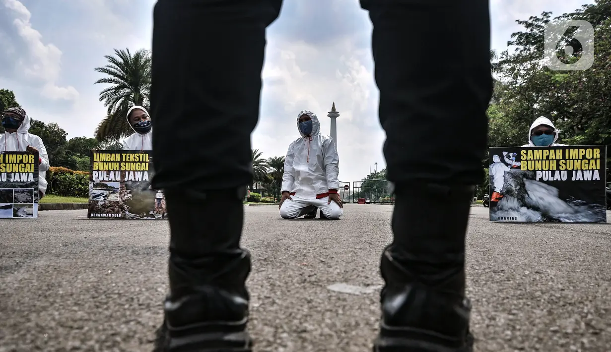 Aktivis membawa poster saat aksi "Sampah Impor Bunuh Sungai Pulau Jawa" di kawasan Patung Kuda, Monas, Jakarta, Senin (3/5/2021). Limbah buangan pabrik merusak ekosistem sistem sungai dan menimbulkan racun. (merdeka.com/Iqbal S. Nugroho)